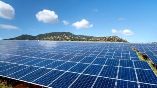 A sprawling solar farm with blue solar panels under a vibrant sky, showcasing renewable energy.