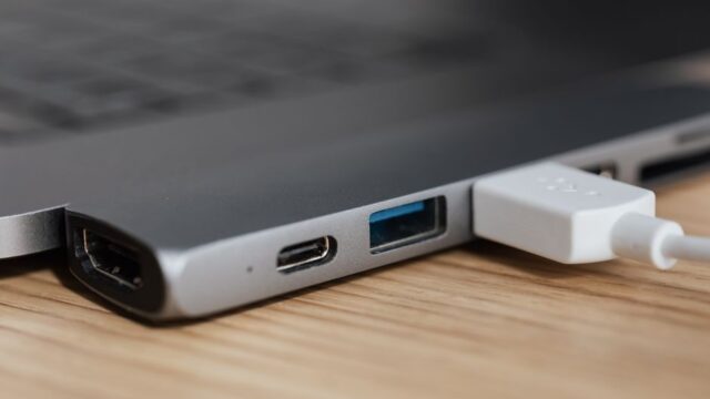 USB type c multiport adapter with plugged white cable connected to modern laptop