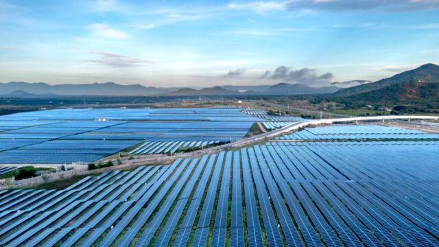 Aerial view of a vast solar farm in Vietnam, showcasing sustainable energy solutions at sunrise.