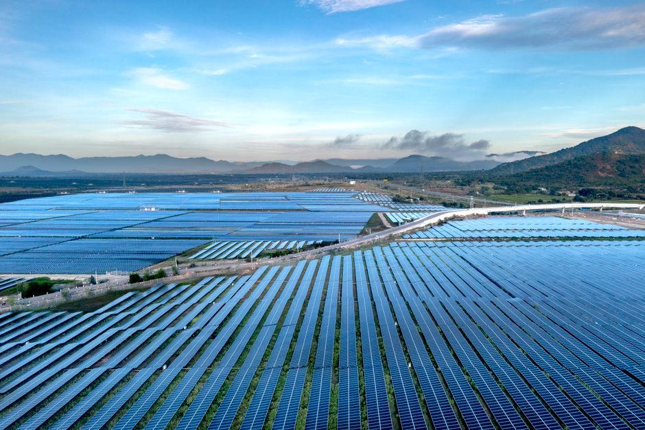 Aerial view of a vast solar farm in Vietnam, showcasing sustainable energy solutions at sunrise.