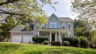 A beautiful suburban house surrounded by trees and lush greenery, perfect for families.