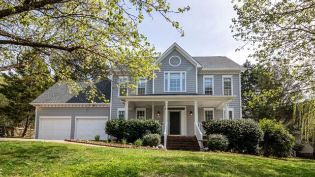 A beautiful suburban house surrounded by trees and lush greenery, perfect for families.