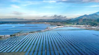 Aerial view of a sprawling solar farm under a vibrant sky in Vietnam's Ninh Thuan during daytime.