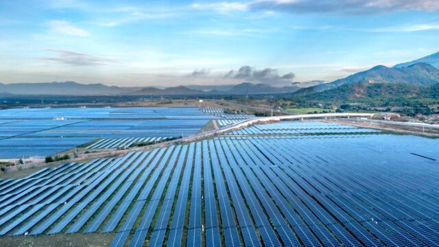 Aerial view of a sprawling solar farm under a vibrant sky in Vietnam's Ninh Thuan during daytime.