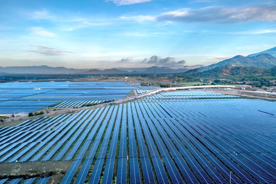 Aerial view of a sprawling solar farm under a vibrant sky in Vietnam's Ninh Thuan during daytime.