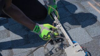 Close-up of a technician working on solar panel installation with green gloves in Tampa, Florida.