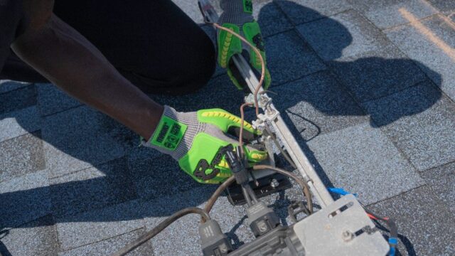 Close-up of a technician working on solar panel installation with green gloves in Tampa, Florida.
