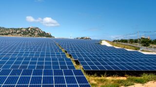 A vast array of solar panels under a clear blue sky, symbolizing renewable energy and sustainability.