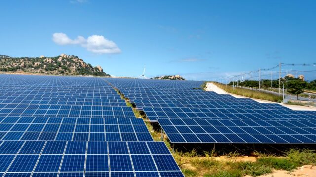 A vast array of solar panels under a clear blue sky, symbolizing renewable energy and sustainability.